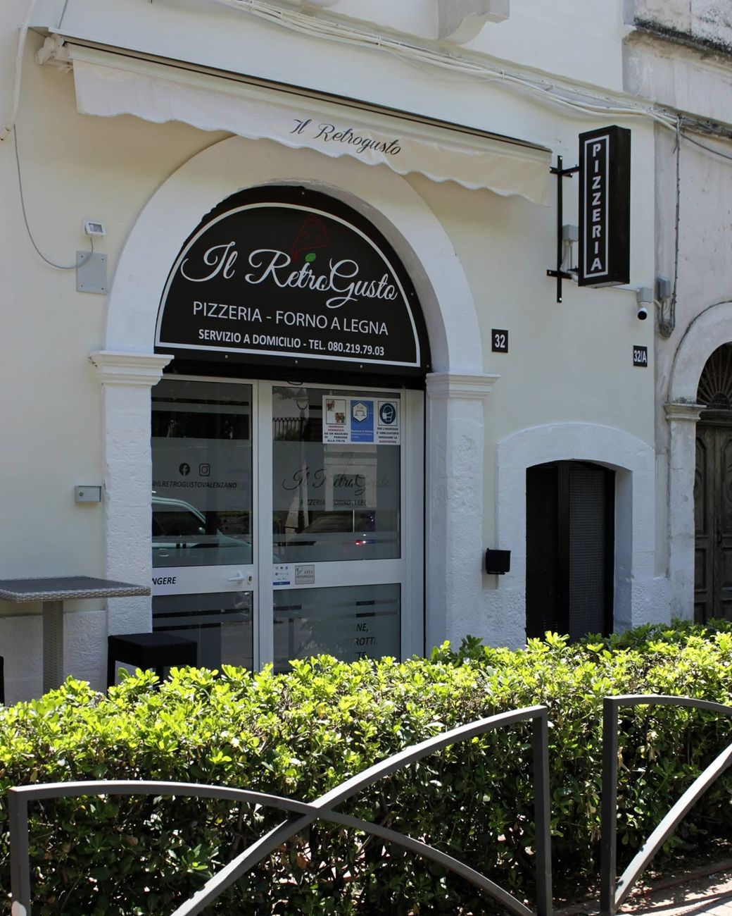 L'ingresso del Retrogusto in Largo Plebiscito, con l'insegna «Pizzeria - forno a legna» e il numero civico 32